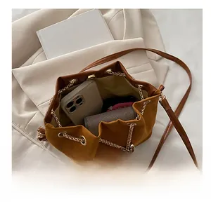Top view of brown suede bucket bag interior showing capacity for smartphone and wallet