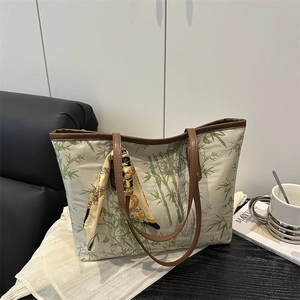 Casual tote bag with green bamboo print, leather handles and silk scarf decoration