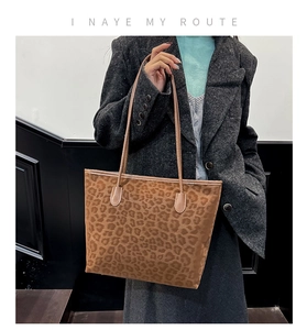 Macro view of leopard print tote bag texture and slim shoulder strap detail