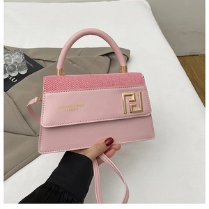 Détail du sac à main en cuir PU rose avec boucle dorée et lettrage fashion imprimé