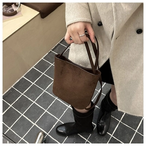 Close-up of a brown suede bucket bag texture paired with a beige winter wool coat