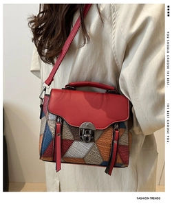 Macro detail of multi-colored geometric patchwork bag with crocodile texture and metal buckle