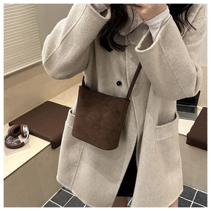 Chic dark brown suede bucket bag styled with a beige wool coat for a cozy winter look