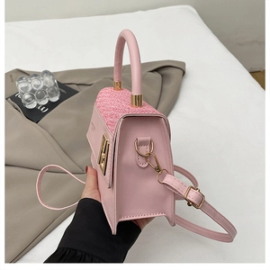 Vue détaillée du sac rose montrant la texture du tissu et les coutures en cuir