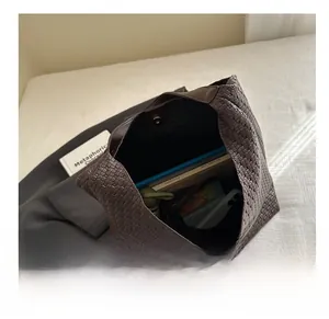 Spacious dark brown woven tote bag interior showing books, umbrella, and phone storage