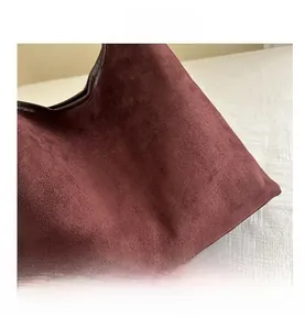 Close-up of the burgundy suede texture and premium stitching on this fashion tote bag
