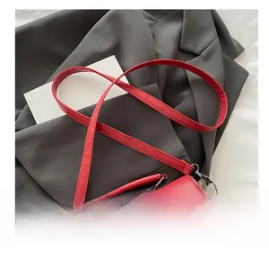 Dettaglio della borsa a tracolla in pelle rossa con cuciture geometriche colorate