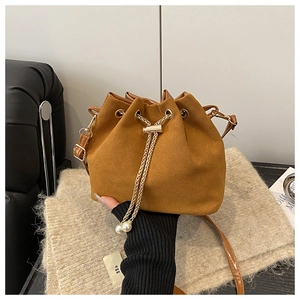 Caramel suede bucket bag detail with golden chain drawstring and pearl charms