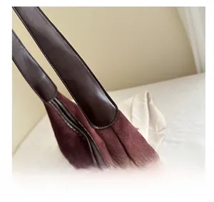Detail shot of the sturdy stitching and premium suede material of the burgundy tote bag