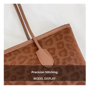 Detail view of precise stitching and animal print texture on brown leather tote bag