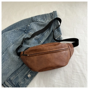 Close-up of vintage brown leather waist bag with litchi texture on denim background