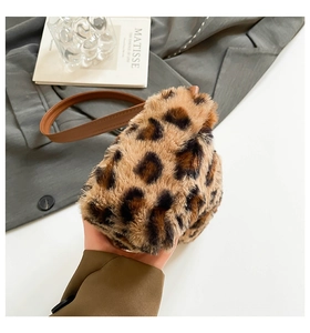 Détail d'un sac en peluche léopard avec bandoulière en cuir marron sur fond élégant