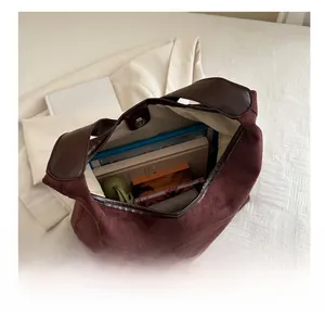 Top view of large burgundy suede tote bag showing spacious interior with books and items