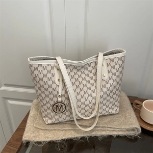 Sac fourre-tout beige chic avec imprimés M et pendentif pour le trajet quotidien