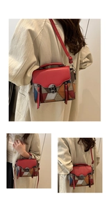Detail of color-block leather handbag featuring red flap and crocodile texture