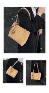 Detail of khaki suede tote bag featuring woven strap and cute plush bear accessory