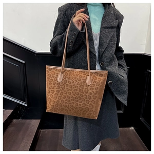 Detail of vintage leopard print tote bag with soft suede texture and long brown straps