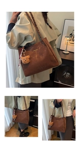 Detail of vintage brown tote bag featuring braided straps and plush bear ornament