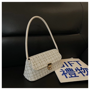 Dettaglio della borsa a spalla in tweed con chiusura dorata e cinturino in pelle