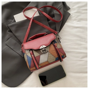 Detail of patchwork leather crossbody bag with crocodile texture on a blazer
