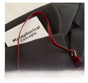 Detail of burgundy patent leather handbag featuring shiny finish and gold square buckle
