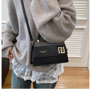 Détail du sac bandoulière en cuir noir avec logo F doré et gaufrage mode élégant