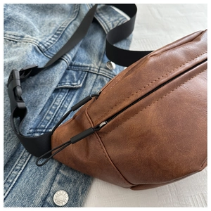 Detailed close-up of brown PU leather crossbody bag with nylon strap and plastic buckle