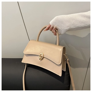 Detailansicht der beigen PU-Ledertasche mit gewölbtem Boden und goldenem Metallverschluss