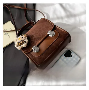 Détails du rabat léopard et des boucles métalliques sur un sac à dos marron vintage