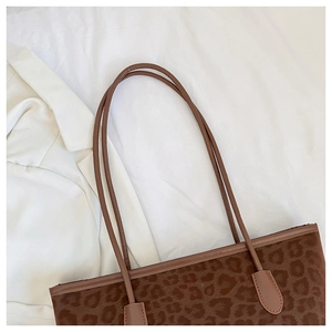 Close-up of leopard print tote bag with soft plush texture and leather handle details