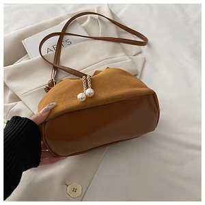 Detail of brown patchwork shoulder bag with elegant pearl charms and gold chain strap