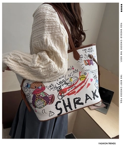Detail of white leather bucket bag featuring unique bear graffiti and brown side drawstrings