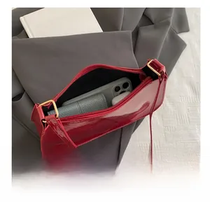 Interior view showing capacity for phone and wallet in red glossy patent leather bag