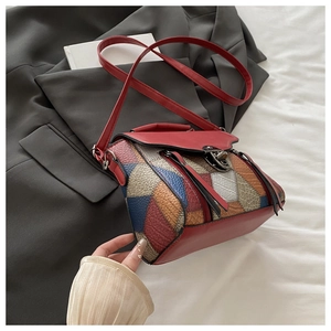 Top view of vintage multi-color patchwork crossbody bag with fringes on a grey blazer