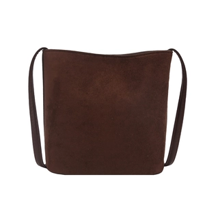 Chic dark brown suede bucket bag with slim leather straps in a minimalist vintage style