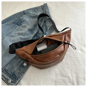 Top view of brown lychee grain PU leather chest bag interior with nylon strap and accessories