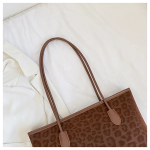 Detailed view of the leopard print tote bag with soft velvet texture on white linen