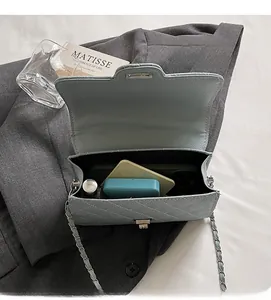 Detail showing the spacious interior of the quilted chain bag with various daily essentials