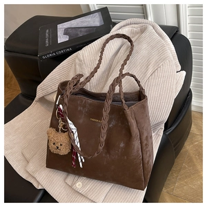 Brown frosted tote bag featuring woven handles with a teddy bear charm and striped scarf