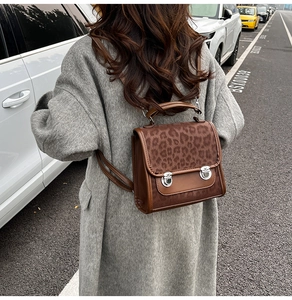 Détail d'un mini sac à dos à imprimé léopard avec boucle argentée porté par un mannequin
