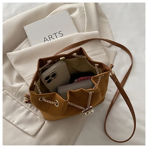 Interior view of brown suede bucket bag showing capacity for phone and wallet with pearl detail