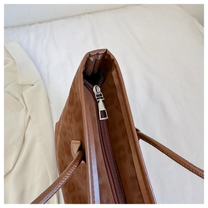 Close-up of silver zipper on brown leopard print tote with soft faux suede texture