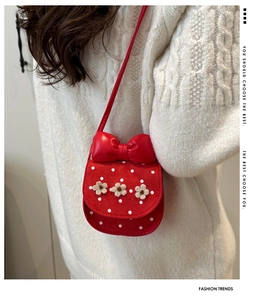 Gros plan du mini sac rouge à pois avec fleurs décoratives et grand nœud élégant
