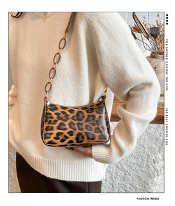 Detail view of leopard print shoulder bag with stylish brown resin chain strap links