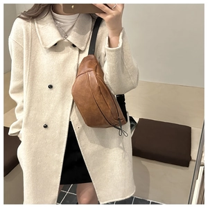 Brown leather chest bag shown worn over a white coat for a casual autumn style