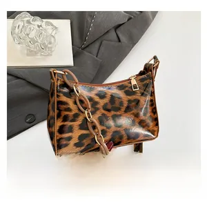 Close-up of leopard print shoulder bag with acrylic chain and glossy texture finish
