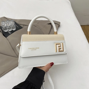 Sac à main blanc minimaliste en cuir avec boucle dorée sur fond de tissu élégant