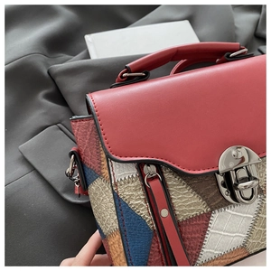 Detail of vintage patchwork handbag featuring red flap and mixed leather texture patterns