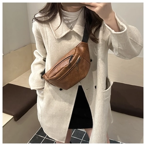Detail of vintage brown PU leather chest bag with zipper and adjustable canvas strap