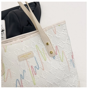 Detail of embossed texture and colorful wavy stitching on white large tote bag